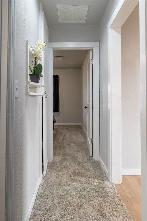 hall featuring light colored carpet