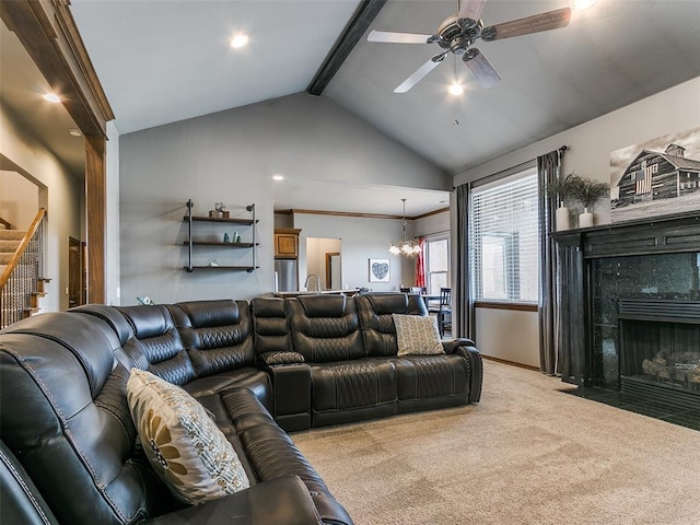 living room with lofted ceiling with beams, ceiling fan with notable chandelier, light colored carpet, and a fireplace