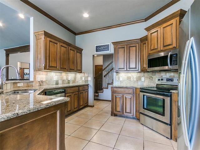 kitchen featuring sink, light stone counters, crown molding, light tile patterned floors, and stainless steel appliances