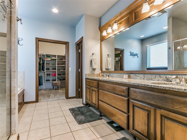 bathroom with vanity, a shower with shower door, and tile patterned floors