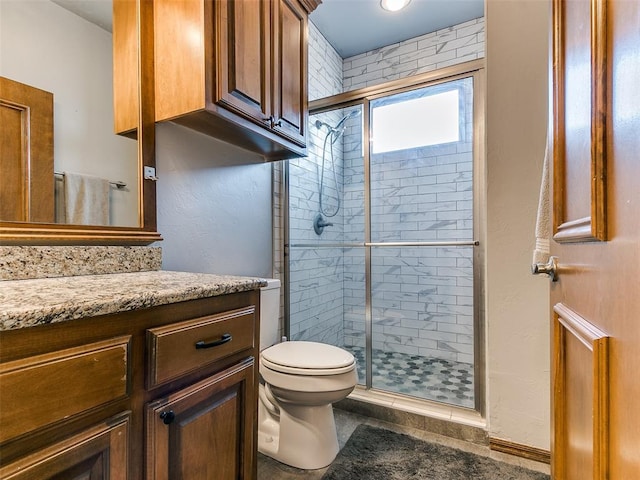 bathroom with vanity, a shower with shower door, and toilet