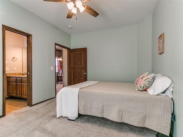 carpeted bedroom with sink, ceiling fan, and ensuite bath