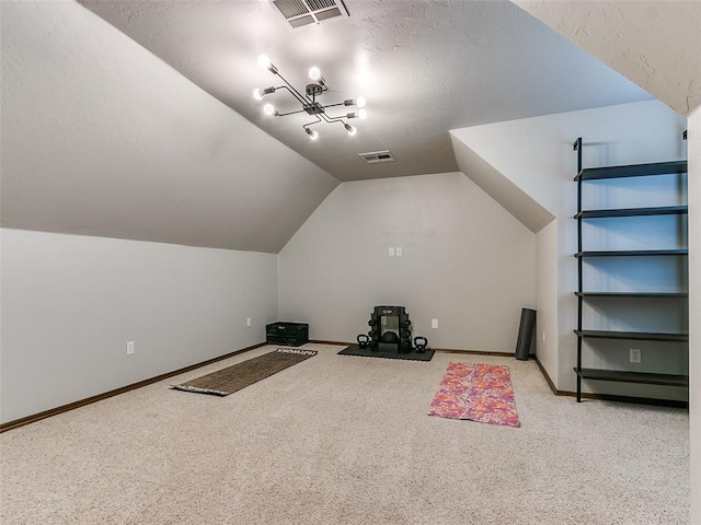 additional living space with built in features, lofted ceiling, carpet, and a textured ceiling