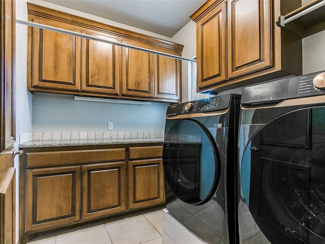 laundry room featuring independent washer and dryer, cabinets, and light tile patterned floors