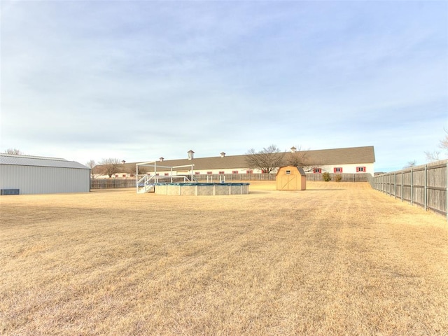 view of yard with a fenced in pool and a storage unit