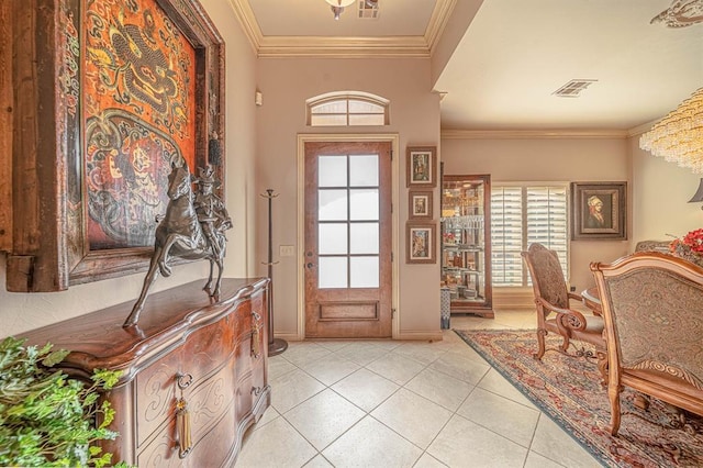 tiled entrance foyer with crown molding and a notable chandelier