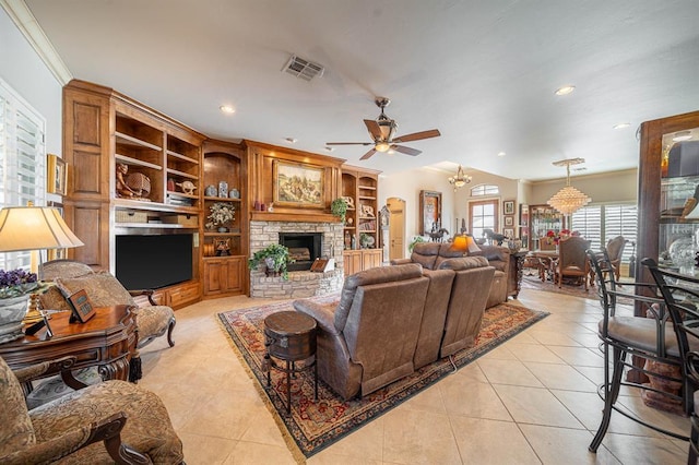 tiled living room featuring built in shelves, ornamental molding, a fireplace, and ceiling fan with notable chandelier