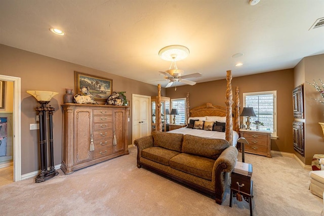 bedroom featuring ceiling fan, light carpet, and multiple windows