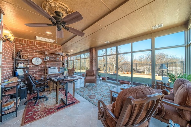 interior space featuring brick wall, light tile patterned floors, and ceiling fan