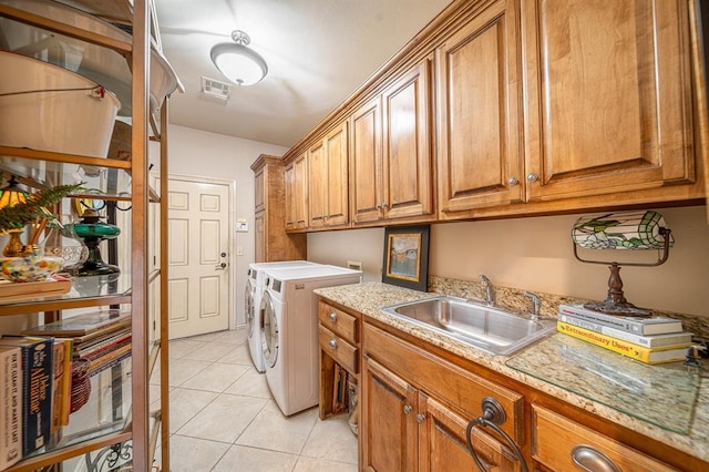 clothes washing area with cabinets, washer and dryer, sink, and light tile patterned floors