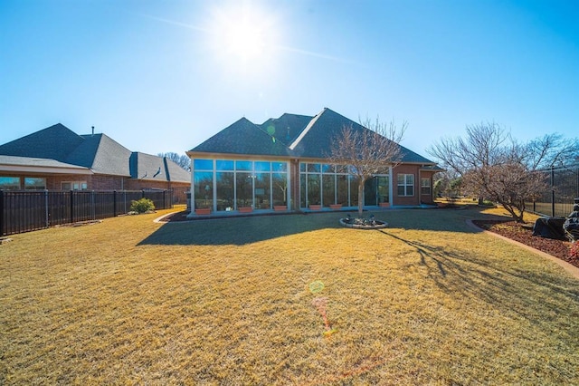 back of property with a sunroom and a yard