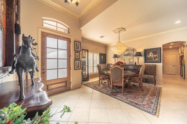 dining space featuring arched walkways, visible vents, crown molding, and light tile patterned floors