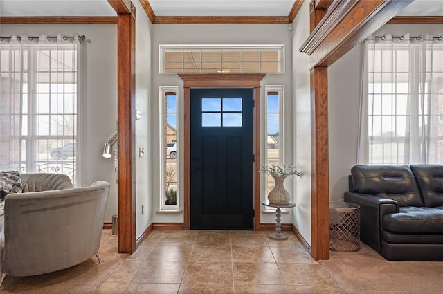 foyer featuring crown molding, a wealth of natural light, and light tile patterned flooring