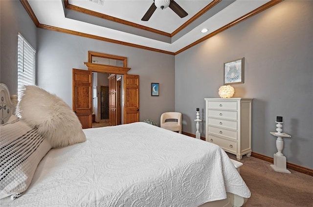 bedroom featuring a tray ceiling, crown molding, ceiling fan, and carpet