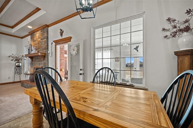 carpeted dining area featuring ornamental molding and a large fireplace