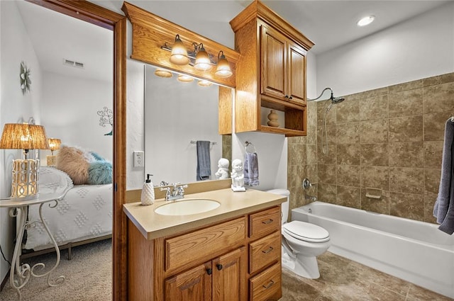 full bathroom featuring vanity, tiled shower / bath combo, tile patterned floors, and toilet