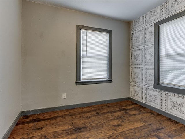 unfurnished room with dark wood-type flooring and a wealth of natural light