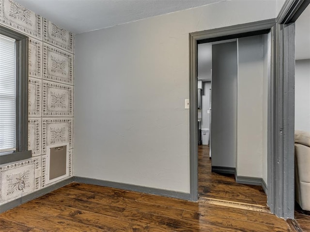 unfurnished bedroom with dark hardwood / wood-style flooring and a closet