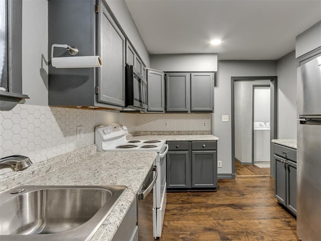 kitchen with stainless steel appliances, gray cabinets, sink, and decorative backsplash