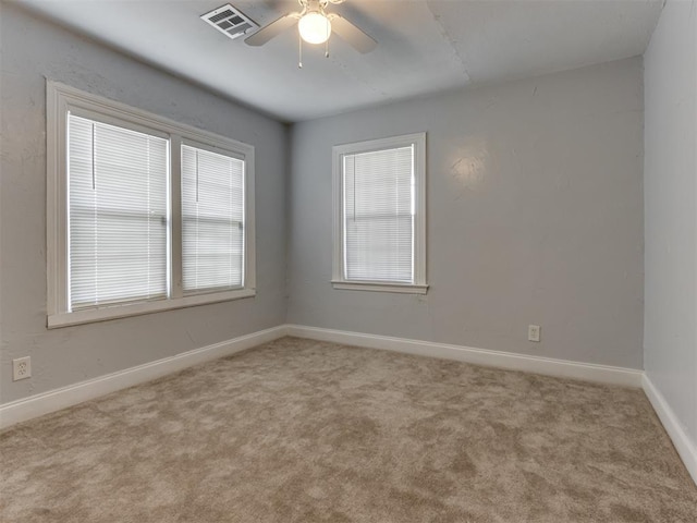 carpeted spare room featuring ceiling fan