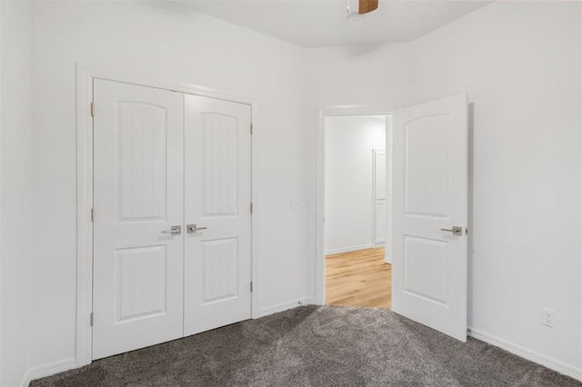 unfurnished bedroom with carpet flooring, ceiling fan, and a closet