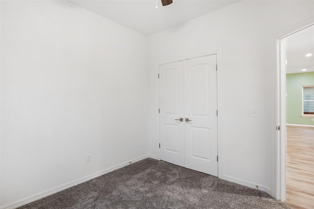 unfurnished bedroom with ceiling fan, carpet, and a closet