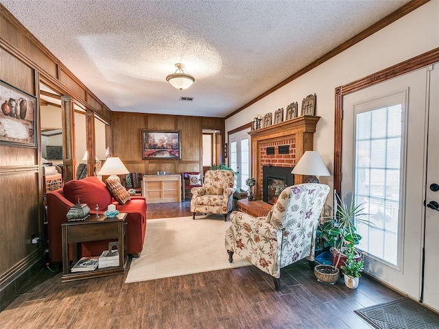 living area with crown molding, a healthy amount of sunlight, and dark hardwood / wood-style flooring