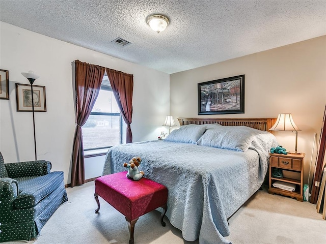 bedroom featuring light carpet and a textured ceiling