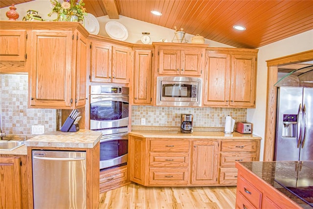 kitchen with appliances with stainless steel finishes, vaulted ceiling with beams, wooden ceiling, and light hardwood / wood-style floors