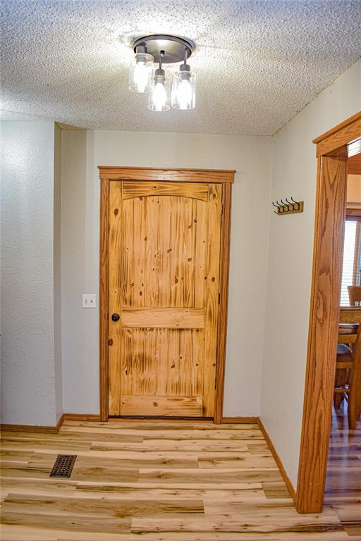 interior space with light hardwood / wood-style floors and a textured ceiling