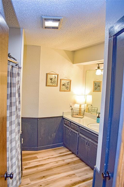 bathroom featuring vanity, hardwood / wood-style floors, and a textured ceiling