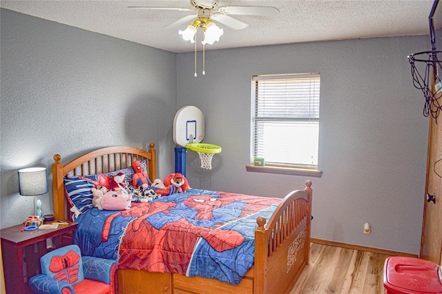 bedroom with ceiling fan, light hardwood / wood-style floors, and a textured ceiling