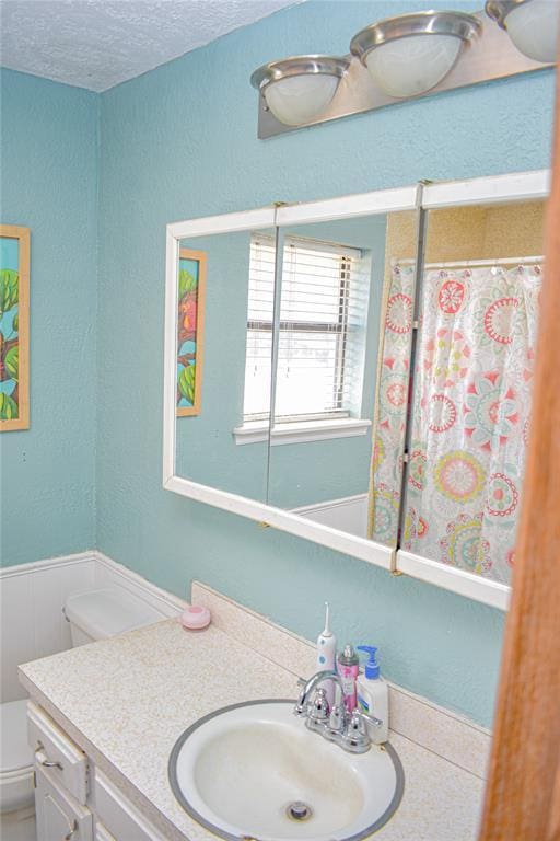 bathroom with vanity, a textured ceiling, and toilet