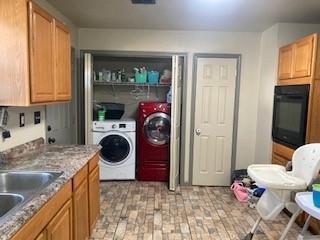 clothes washing area featuring separate washer and dryer and sink