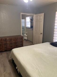 bedroom with multiple windows and dark hardwood / wood-style floors