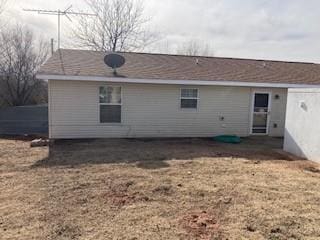 rear view of property featuring a lawn