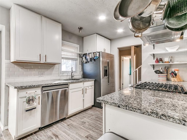 kitchen featuring white cabinetry, appliances with stainless steel finishes, light stone countertops, and sink