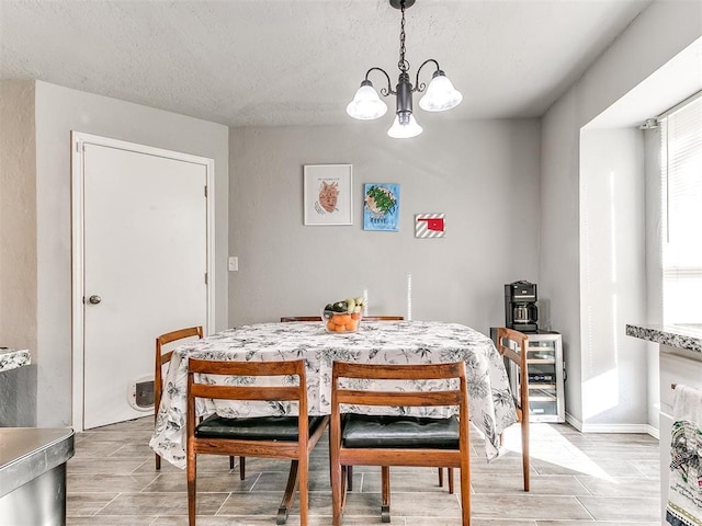 dining space with an inviting chandelier and a textured ceiling