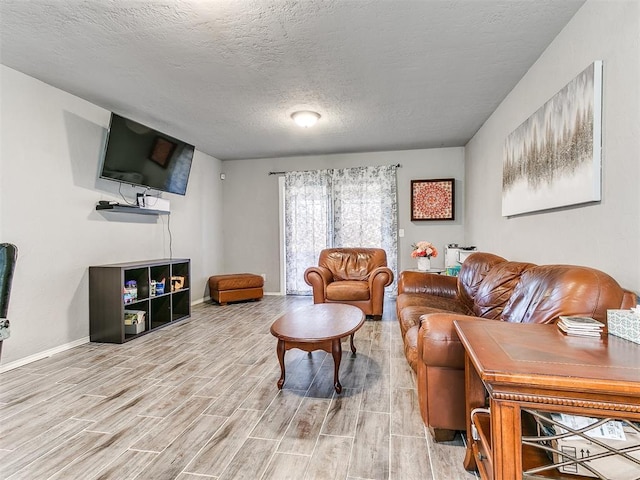 living room featuring a textured ceiling and light wood-type flooring