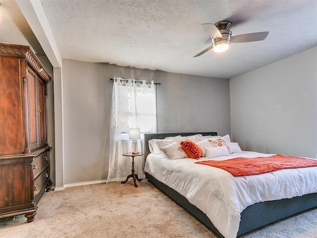 carpeted bedroom with ceiling fan and a textured ceiling