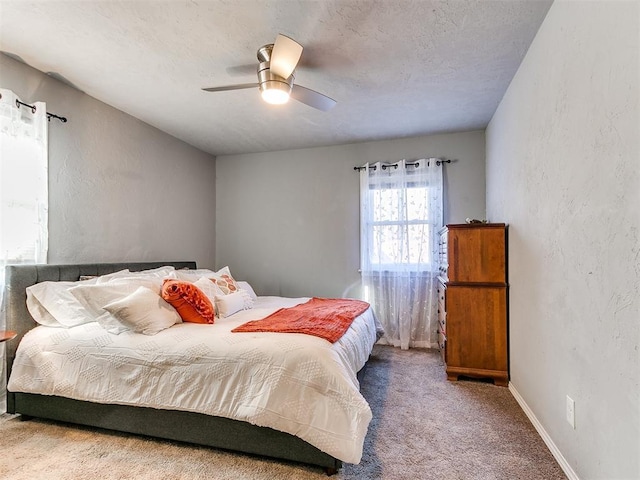 carpeted bedroom with a textured ceiling and ceiling fan