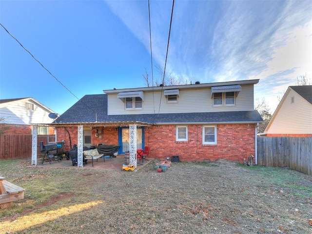 back of house featuring a patio and a yard