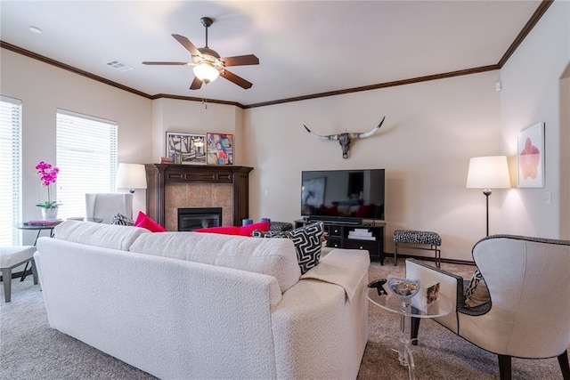 carpeted living room featuring ornamental molding, ceiling fan, and a fireplace