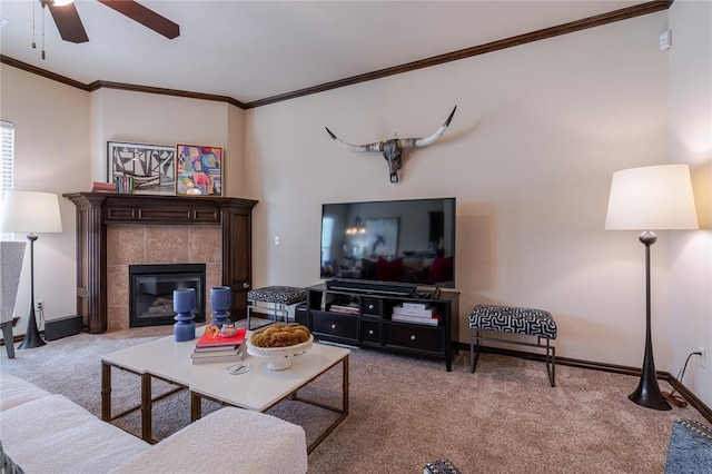 living room featuring a tile fireplace, ornamental molding, light carpet, and ceiling fan