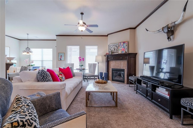 living room featuring crown molding, carpet floors, ceiling fan, and a fireplace