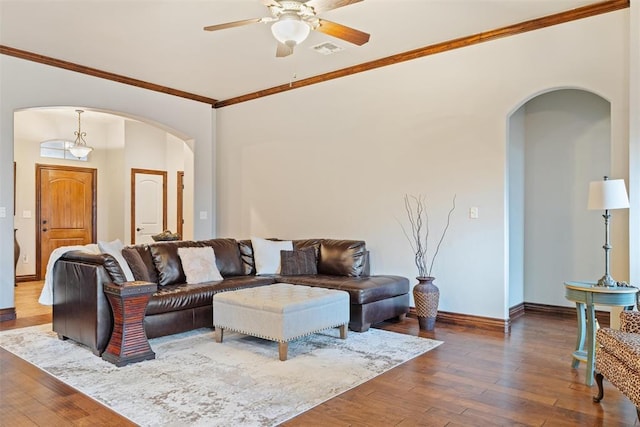 living room with crown molding, dark wood-type flooring, and ceiling fan