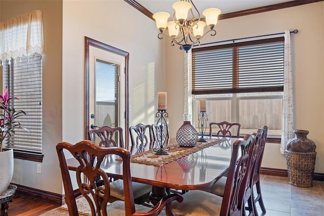 dining space with an inviting chandelier, ornamental molding, and tile patterned flooring