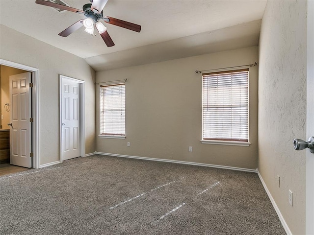 unfurnished bedroom featuring carpet floors, vaulted ceiling, and ceiling fan