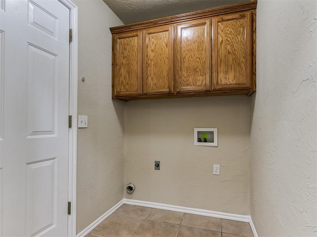 washroom with cabinets, hookup for an electric dryer, washer hookup, and light tile patterned floors