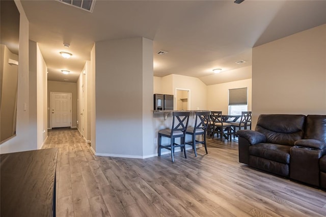 living room with vaulted ceiling and light hardwood / wood-style floors